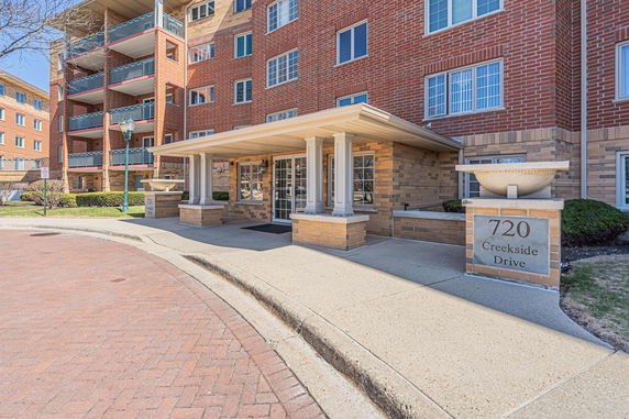 Front view of a multi-story brick building with a covered entrance.