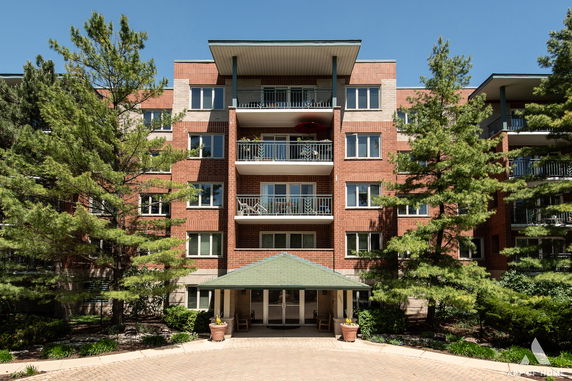 Front view of a multi-story brick residential building with balconies.