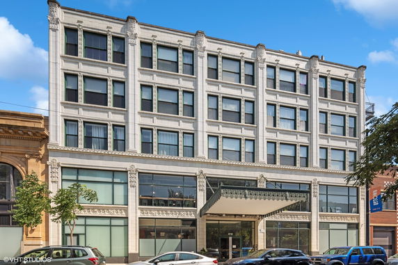 Front view of a multi-story building with a decorative facade and large windows.