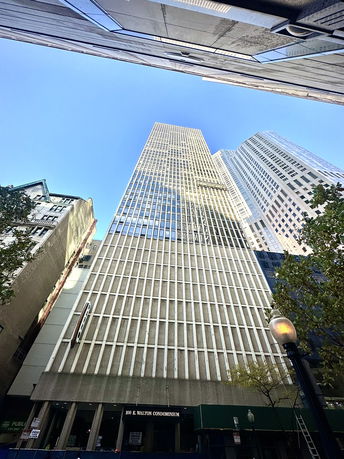 View of a tall condominium building from street level looking up.