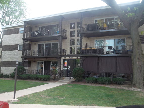 Front view of a three-story apartment building with balconies.
