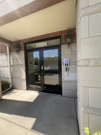 Front view of a building entrance with a glass door and address number 5924.