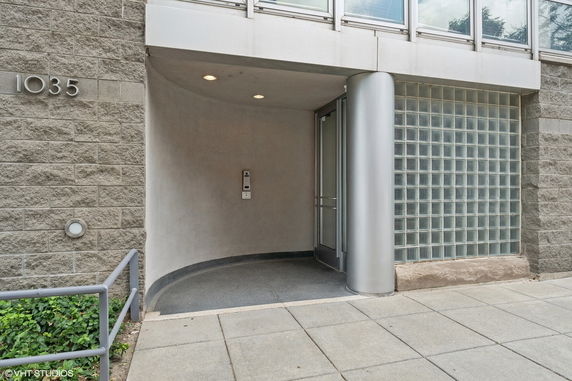 Entrance of a modern building with a curved design and glass block wall.