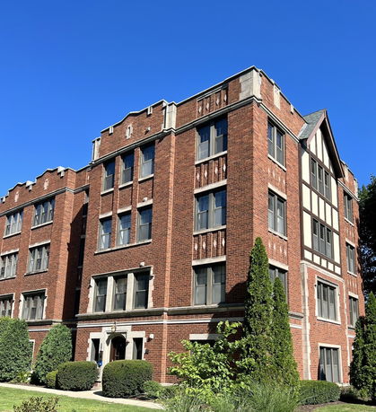 Front view of a multi-story brick building with decorative architectural elements.
