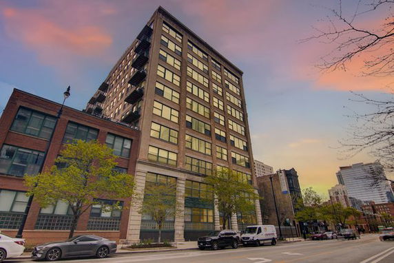 Front view of a multi-story building with large windows and brick exterior.