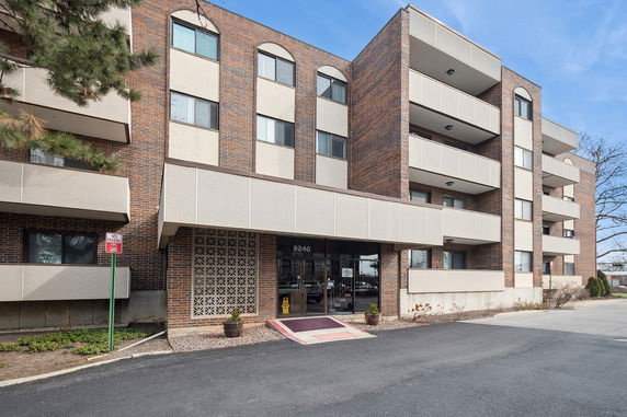 Front view of a multi-story brick building with balconies.