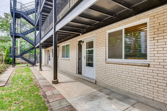 Side view of a building with a brick exterior and external staircase.