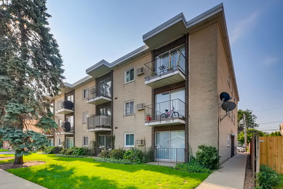 Front view of a multi-story apartment building with balconies.