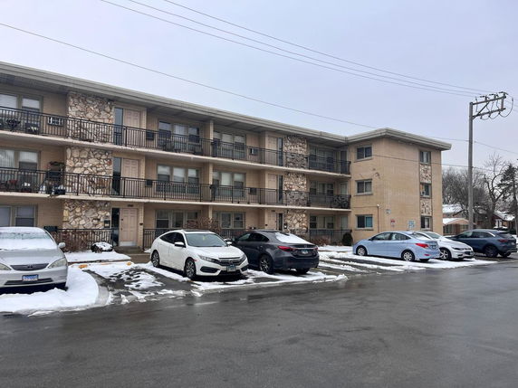 Front view of a three-story apartment building with balconies.