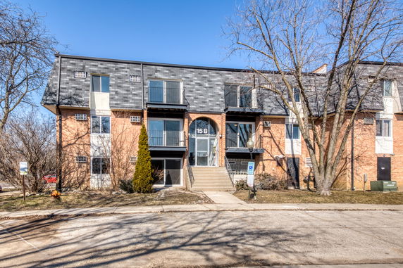 Front view of a multi-story residential building with brick facade and multiple balconies.