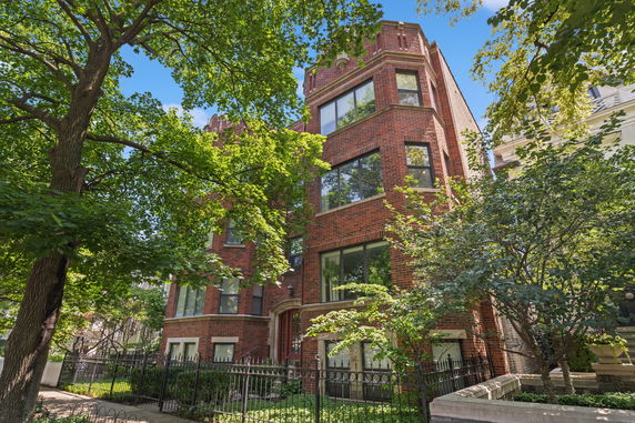 Front view of a multi-story brick building with large windows.