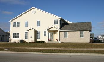 Front view of a two-story house with a combination of brick and siding.