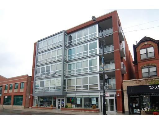 Front view of a multi-story building with large windows and brick accents.