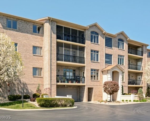 Front view of a multi-story apartment building with balconies.