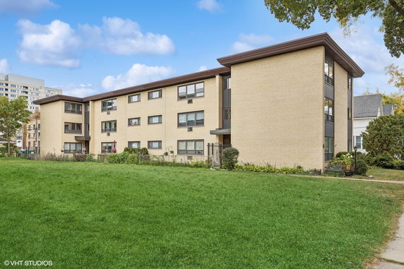 Front view of a three-story apartment building with a flat roof.