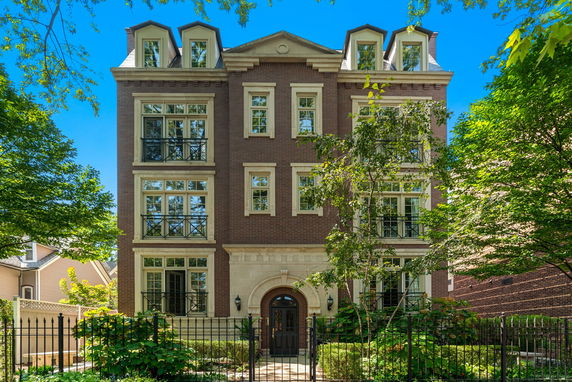 Front view of a multi-story brick building with decorative windows and a central arched entrance.