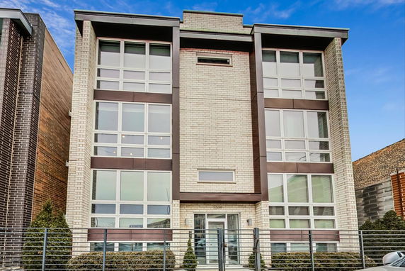 Front view of a modern multi-story building with large windows.
