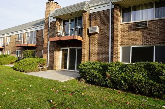 Front view of a two-story brick apartment building with balconies.
