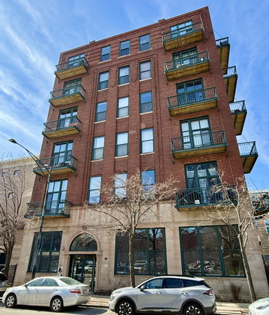 Front view of a multi-story brick building with balconies.