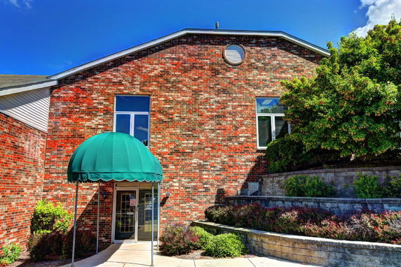 Front view of a brick building with an entrance canopy.