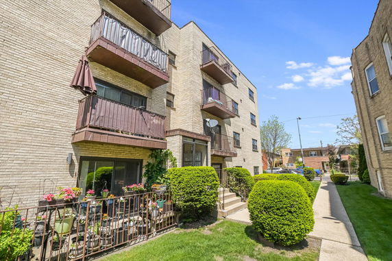 Front view of a multi-story apartment building with balconies.