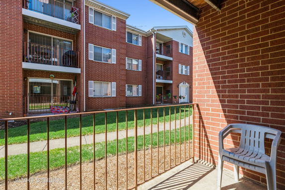 Exterior view of a multi-story brick apartment building with balconies.