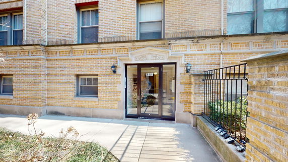Front view of a brick building with a glass entrance door.