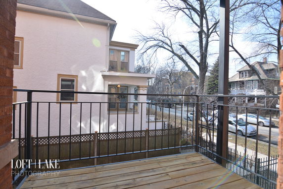 View from a balcony showing nearby houses and street.