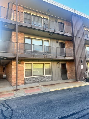 Front view of a three-story apartment building with balconies.