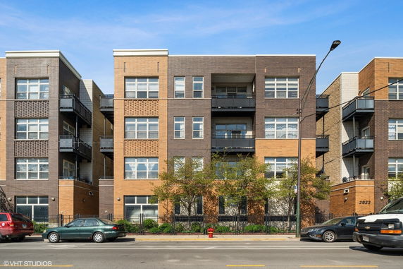 Front view of a modern multi-story apartment building with balconies.