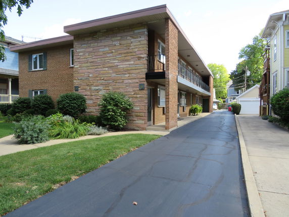 Front view of a two-story apartment building with brick and stone exterior.