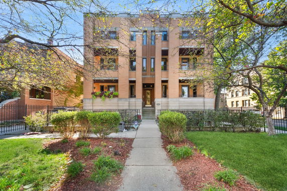 Front view of a multi-story brick building with balconies.