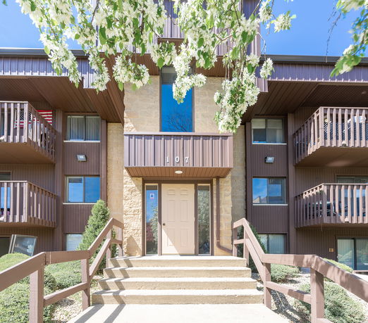 Front view of a multi-story apartment building with balconies.