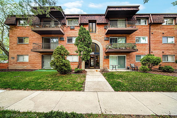 Front view of a two-story apartment building with balconies.