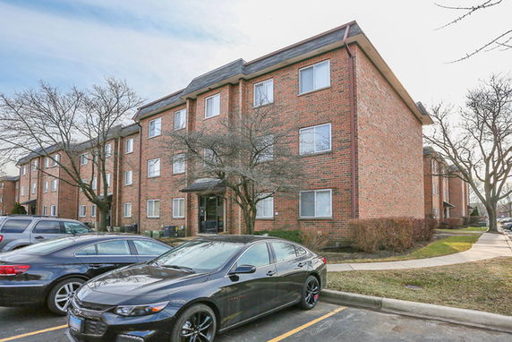 Front view of a multi-story brick apartment building.