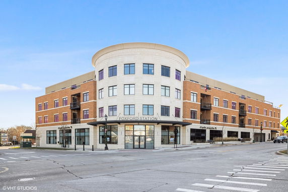 Front view of a multi-story building with a curved and rectangular design, named Foxford Station.