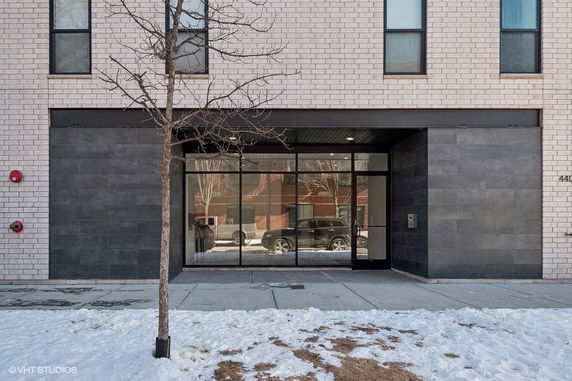 Front view of a modern building with large glass entryway.