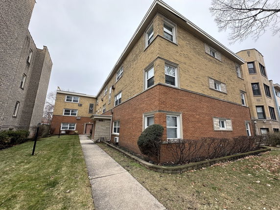 Front view of a multi-story brick apartment building.