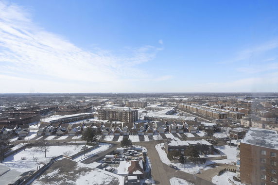 Panoramic view of a snowy urban area with buildings and roads.