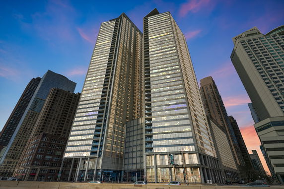 Front view of two tall modern skyscrapers with glass exteriors.