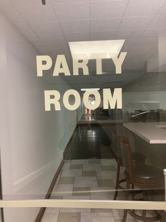 Interior view of a room labeled 'Party Room' with tables and chairs.