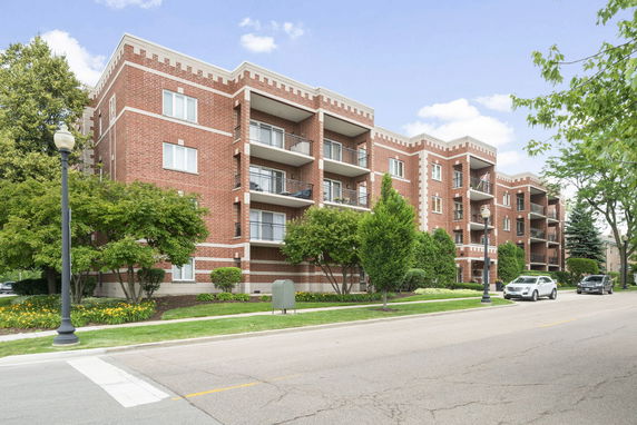 Front view of a multi-story brick apartment building with balconies.