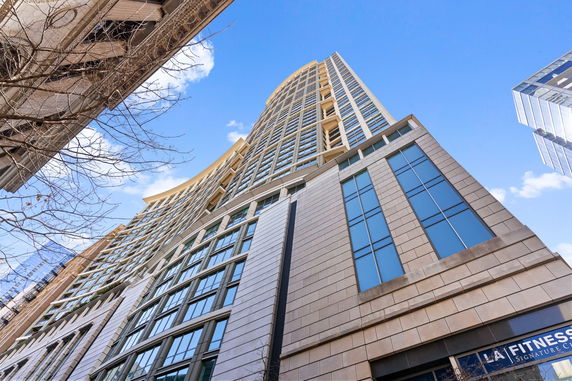 Upward view of a modern high-rise building with glass and stone exterior.