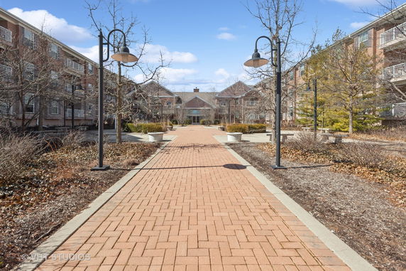 Front view of a multi-story brick building with a pathway leading to the entrance.