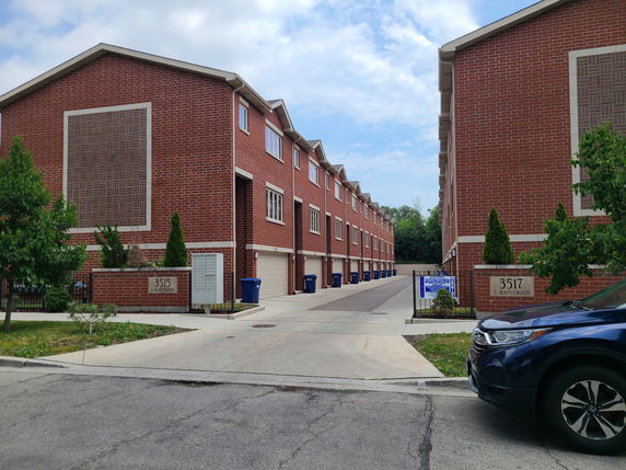 Front view of a row of red brick townhouses with garages.
