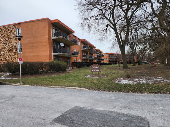 Front view of a multi-story apartment building with balconies.
