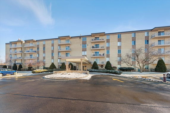 Front view of a multi-story residential building with balconies.