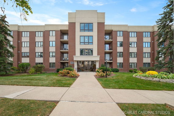 Front view of a multi-story building with a brick facade and balconies.