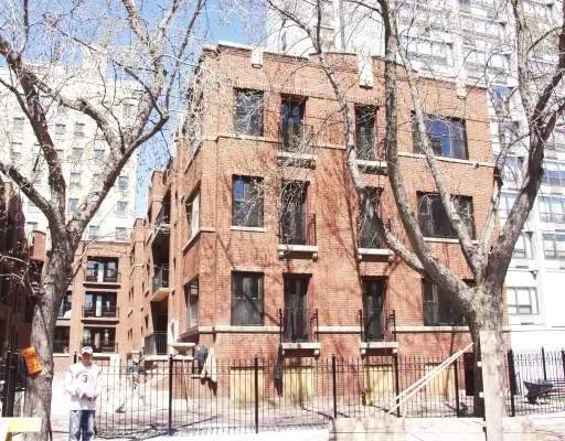 Front view of a red brick multi-story building with multiple windows.