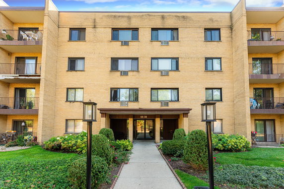 Front view of a multi-story apartment building with balconies.